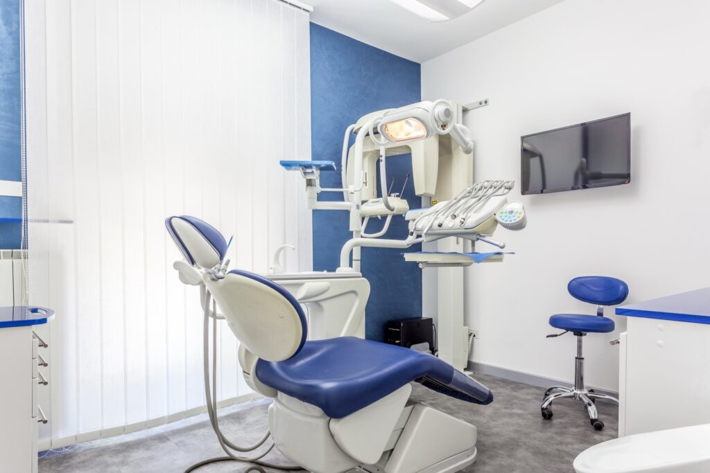 Modern dental practice treatment room with dental chair and equipment